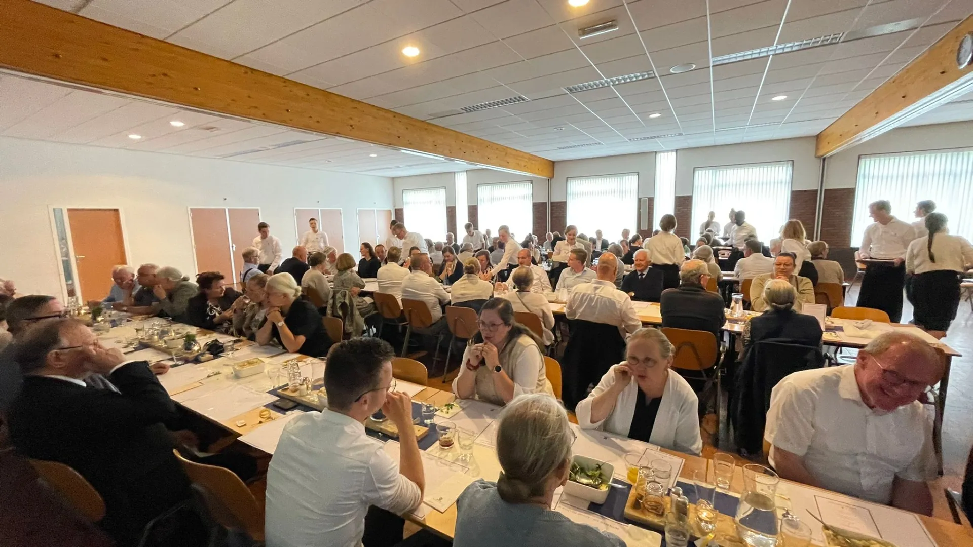 Gemeenteleden nuttigen een maaltijd met elkaar